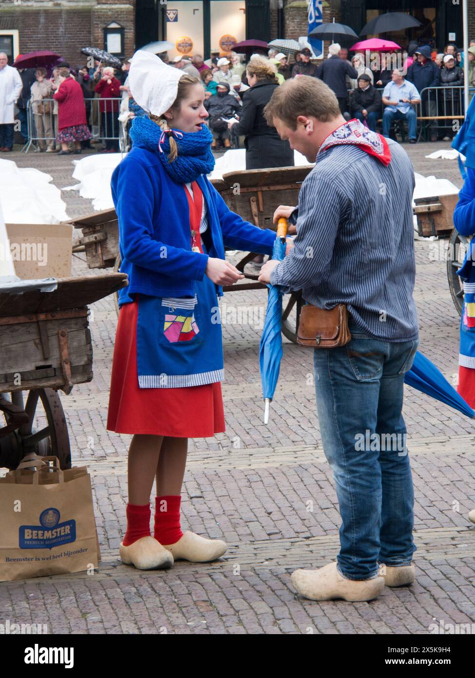 Pays-Bas, Hollande du Nord, Alkmaar. Cheese girl, kaasmeisje, en costume traditionnel vend des échantillons de fromage au marché du fromage d'Alkmaar. (Usage éditorial uniquement) Banque D'Images