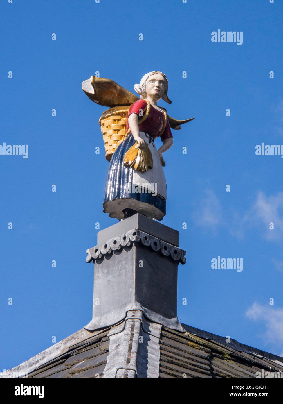 Gros plan d'une statue d'une femme néerlandaise tenant un panier avec un poisson sur le toit de l'ancien marché aux poissons du début du XIXe siècle. (Usage éditorial uniquement) Banque D'Images