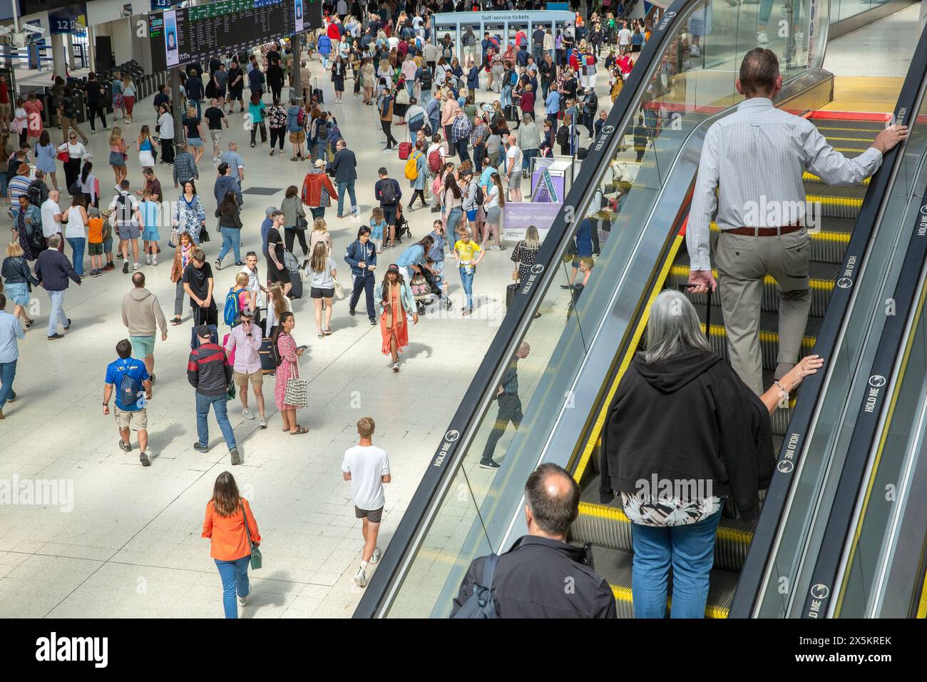 Les gens avec des valises se rassemblent à la gare de Waterloo à Londres alors que le week-end de vacances commence. Banque D'Images