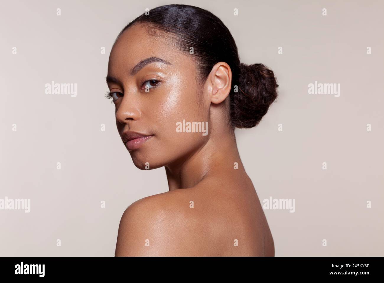 Portrait of young woman looking over shoulder Banque D'Images