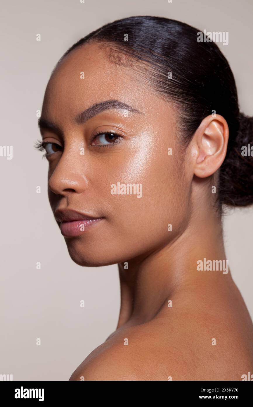 Portrait of young woman looking over shoulder Banque D'Images