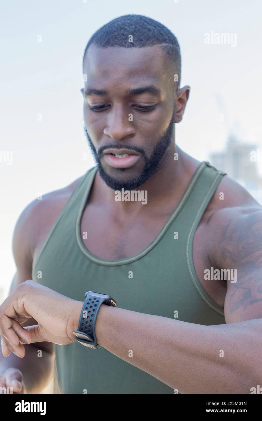 Homme adulte moyen regardant montre-bracelet Banque D'Images