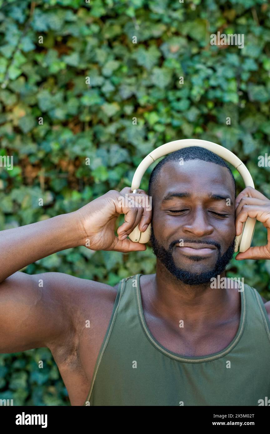 Homme adulte moyen avec écouteurs Banque D'Images