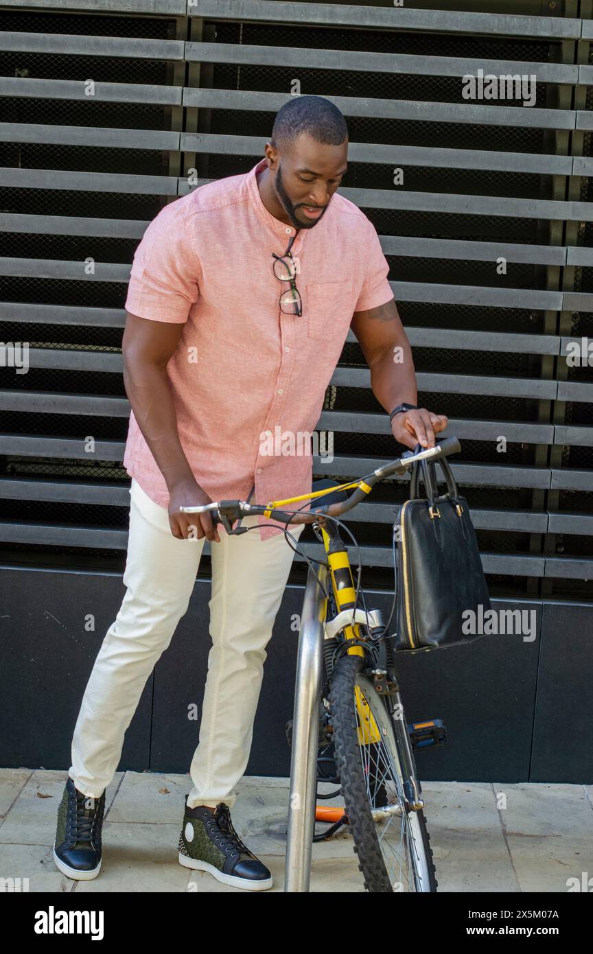 Homme tirant le vélo hors du porte-vélos Banque D'Images