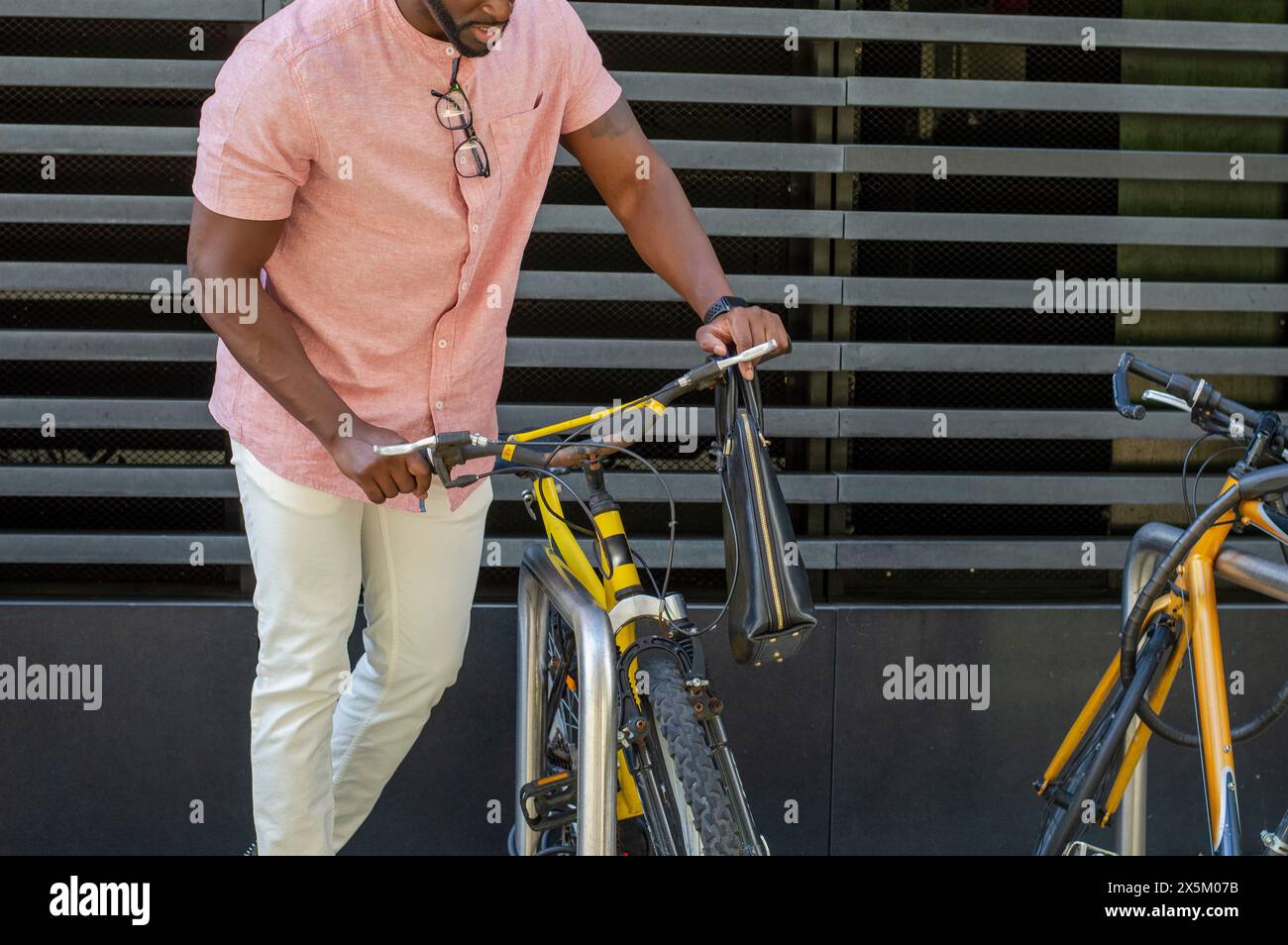 Homme tirant le vélo hors du porte-vélos Banque D'Images