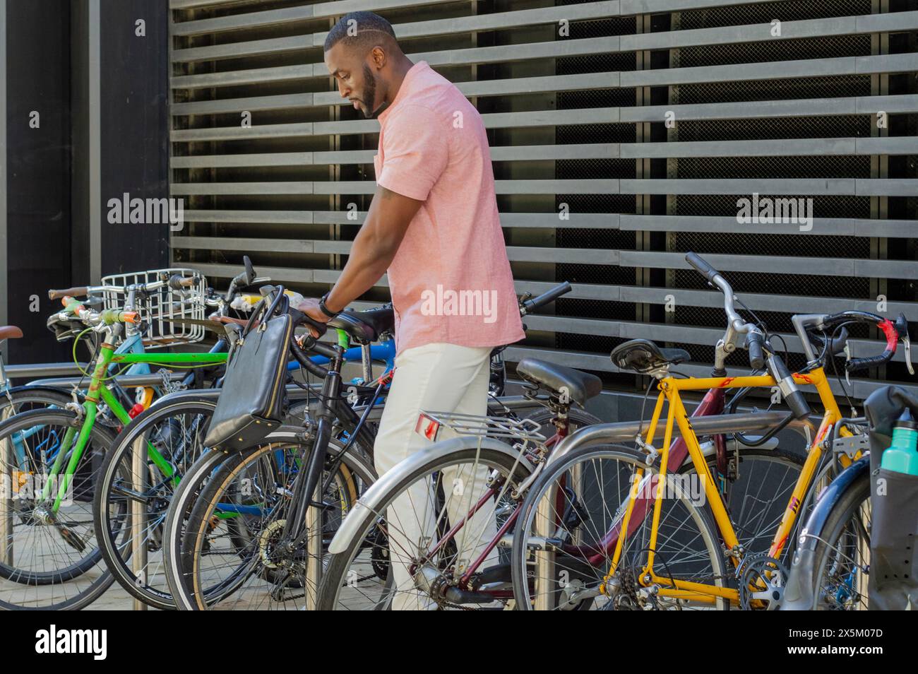 Homme tirant le vélo hors du porte-vélos Banque D'Images