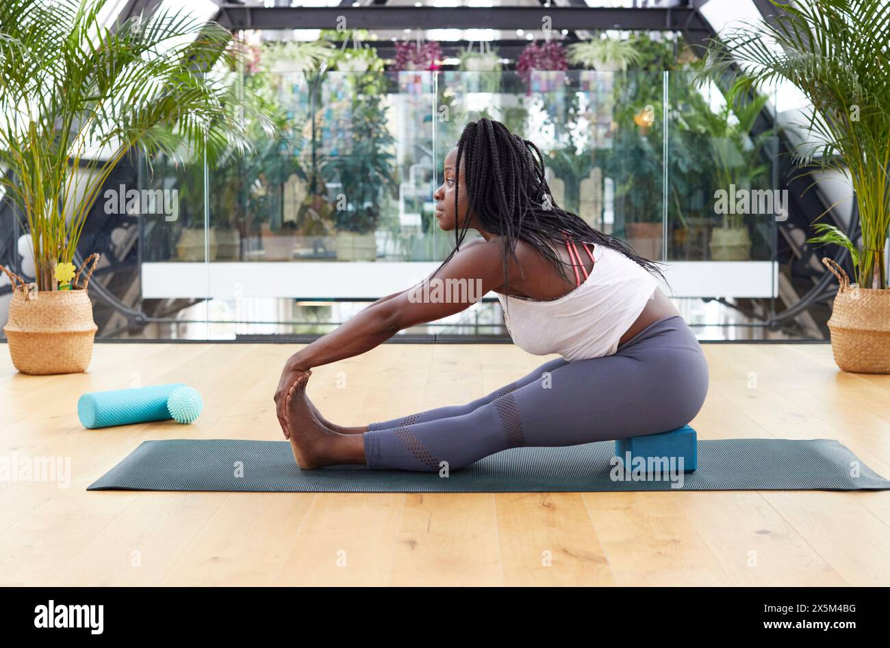 Woman stretching on yoga mat Banque D'Images