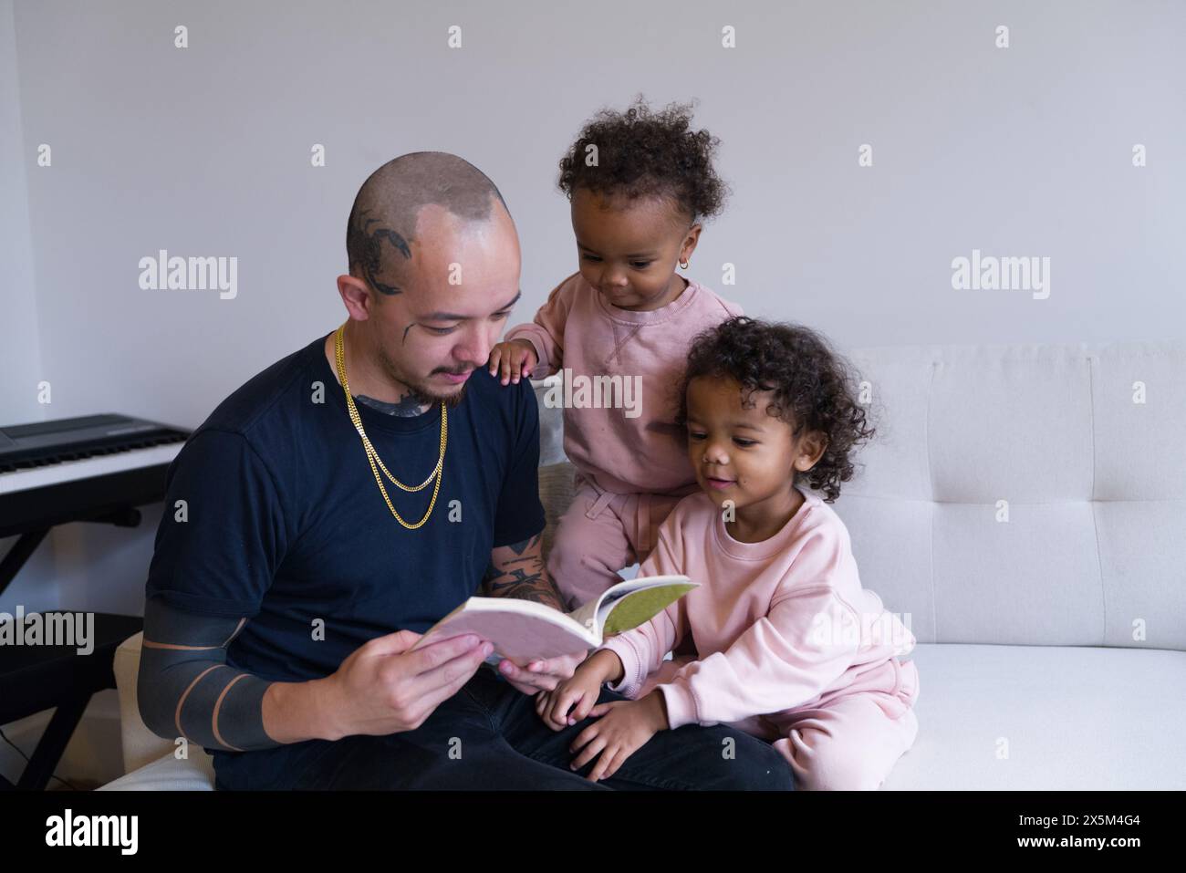 Père lisant avec ses filles Banque D'Images