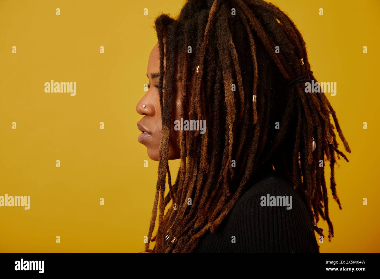 Profil de femme avec des dreadlocks sur fond jaune Banque D'Images