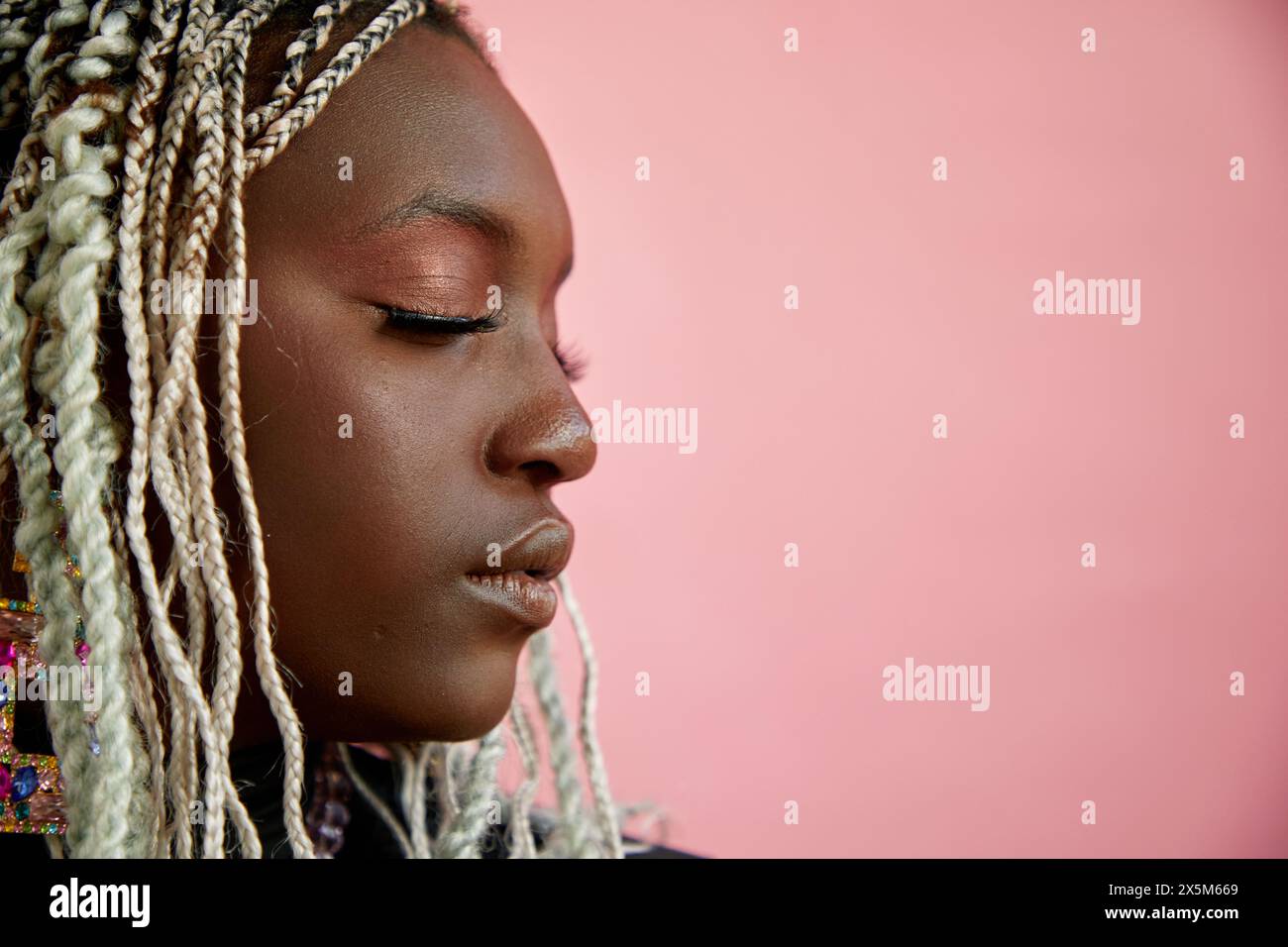 Profil d'une femme aux cheveux tressés blanchis et aux yeux fermés Banque D'Images