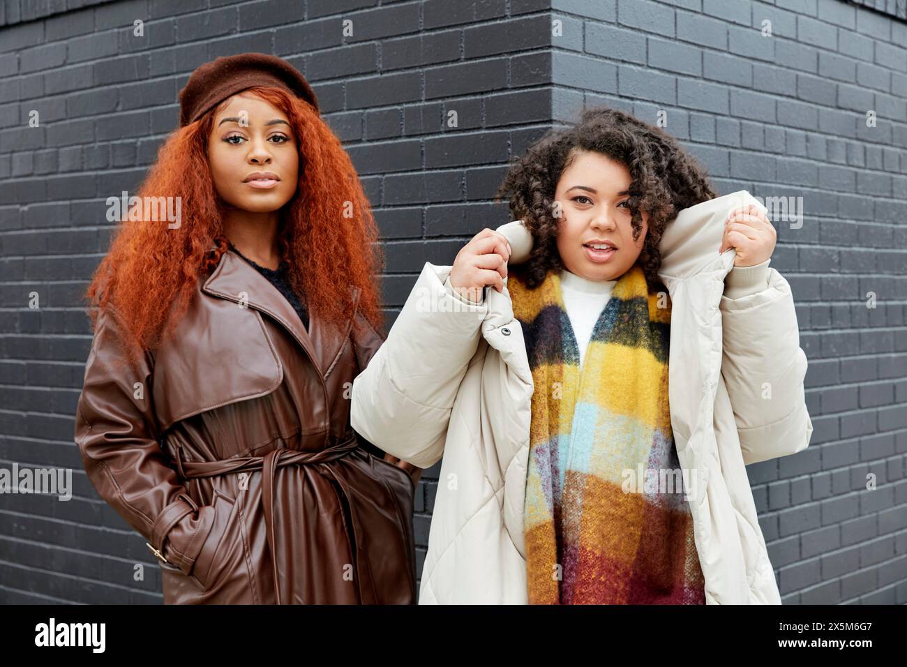 Portrait de femmes élégantes devant un bâtiment noir Banque D'Images