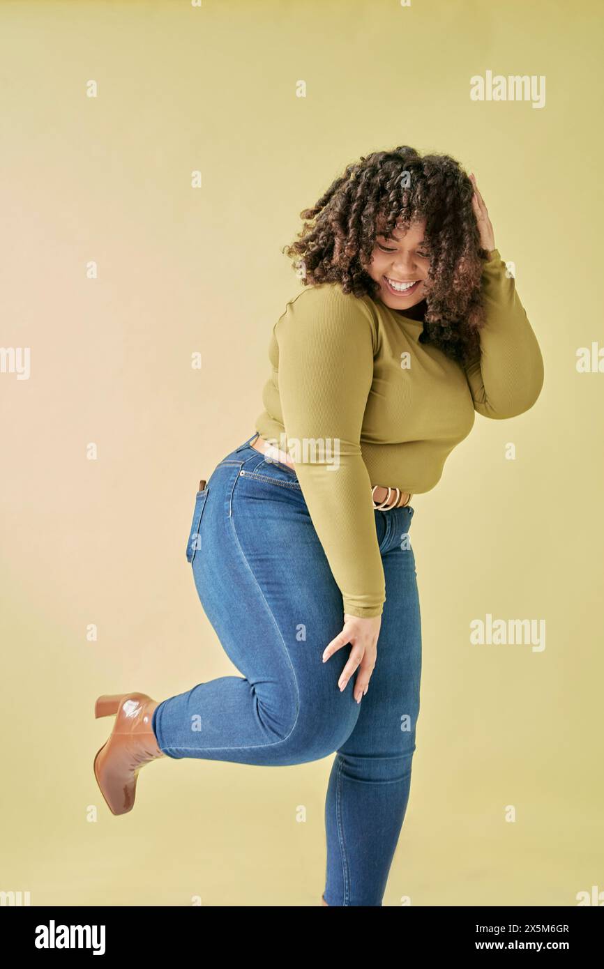 Photo de studio d'une jeune femme souriante debout sur une jambe Banque D'Images