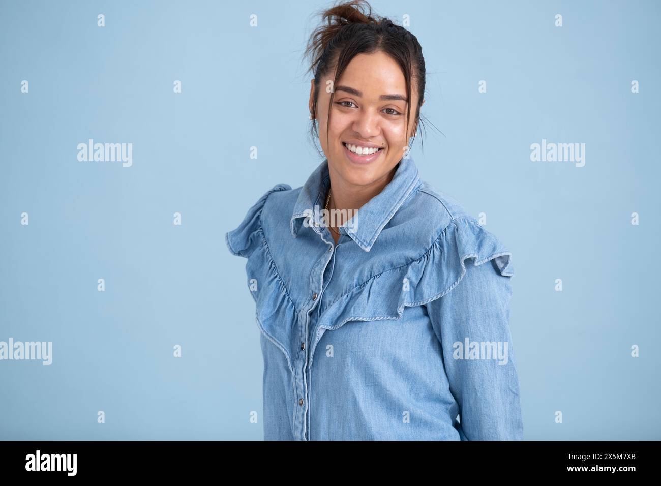 Portrait studio d'une jeune femme portant une chemise bleue Banque D'Images