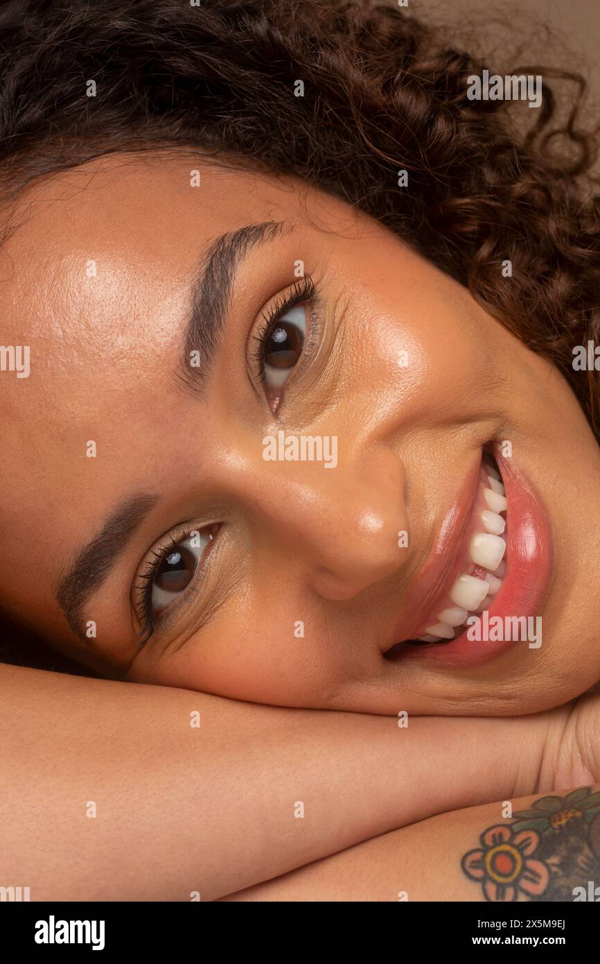 Gros plan d'une femme souriante avec des cheveux bouclés Banque D'Images