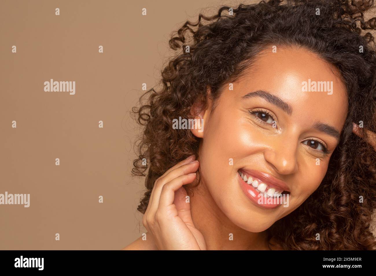 Gros plan d'une femme souriante avec des cheveux bouclés Banque D'Images