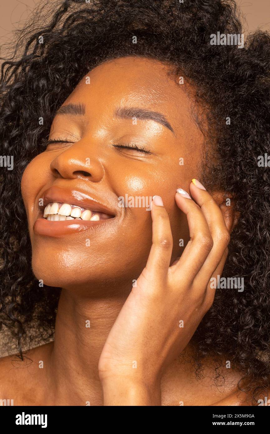 Photo de studio d'une femme souriante avec des cheveux bouclés Banque D'Images