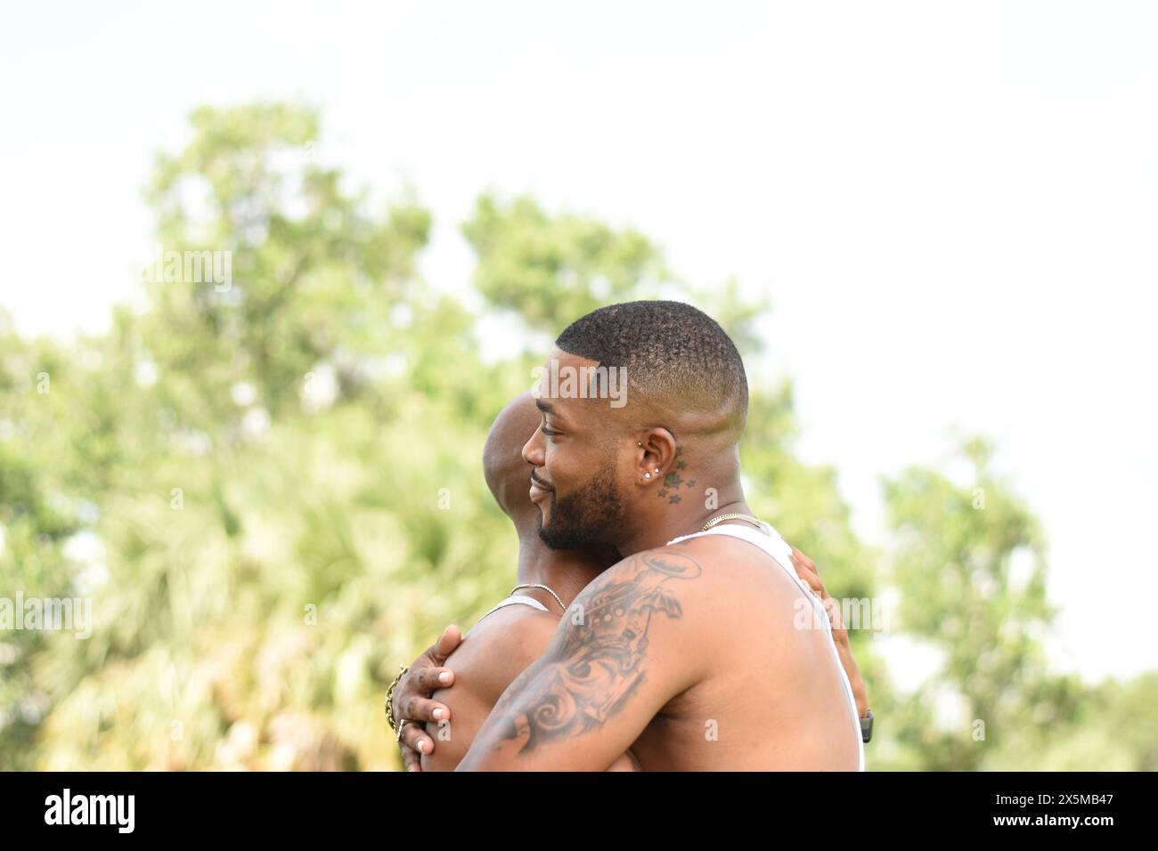 USA, Louisiane, couple gay embrassant dans le parc Banque D'Images USA, Louisiane, couple gay embrassant dans le parc Banque D'Images