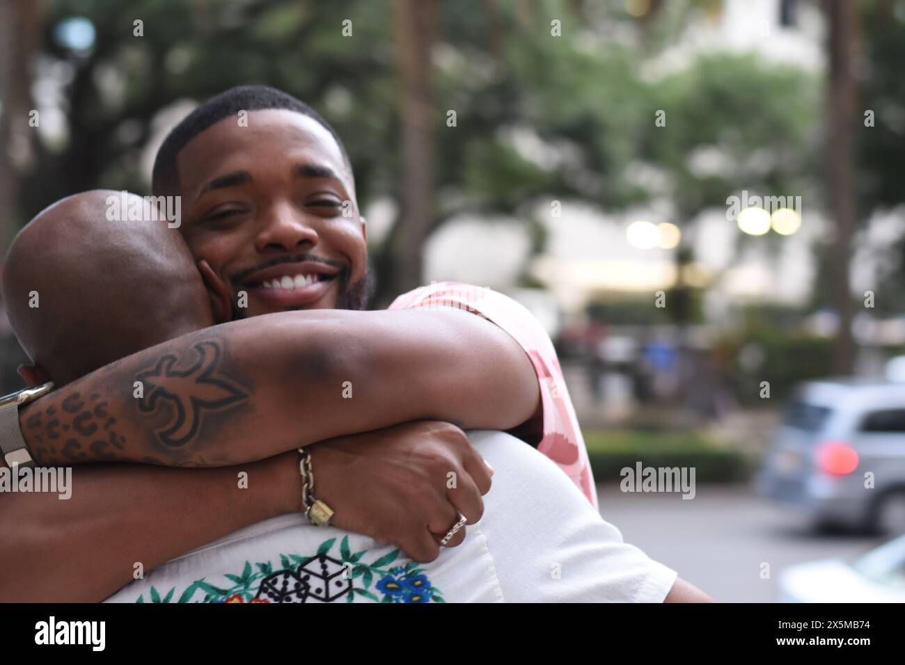 USA, Louisiane, couple gay souriant embrassant en ville Banque D'Images USA, Louisiane, couple gay souriant embrassant en ville Banque D'Images