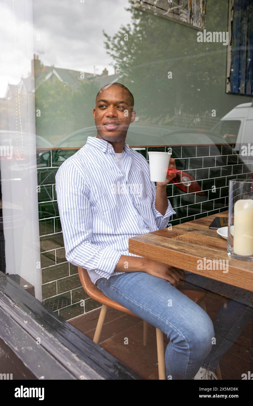 Royaume-Uni, Londres, homme appréciant le café à la table de café Banque D'Images