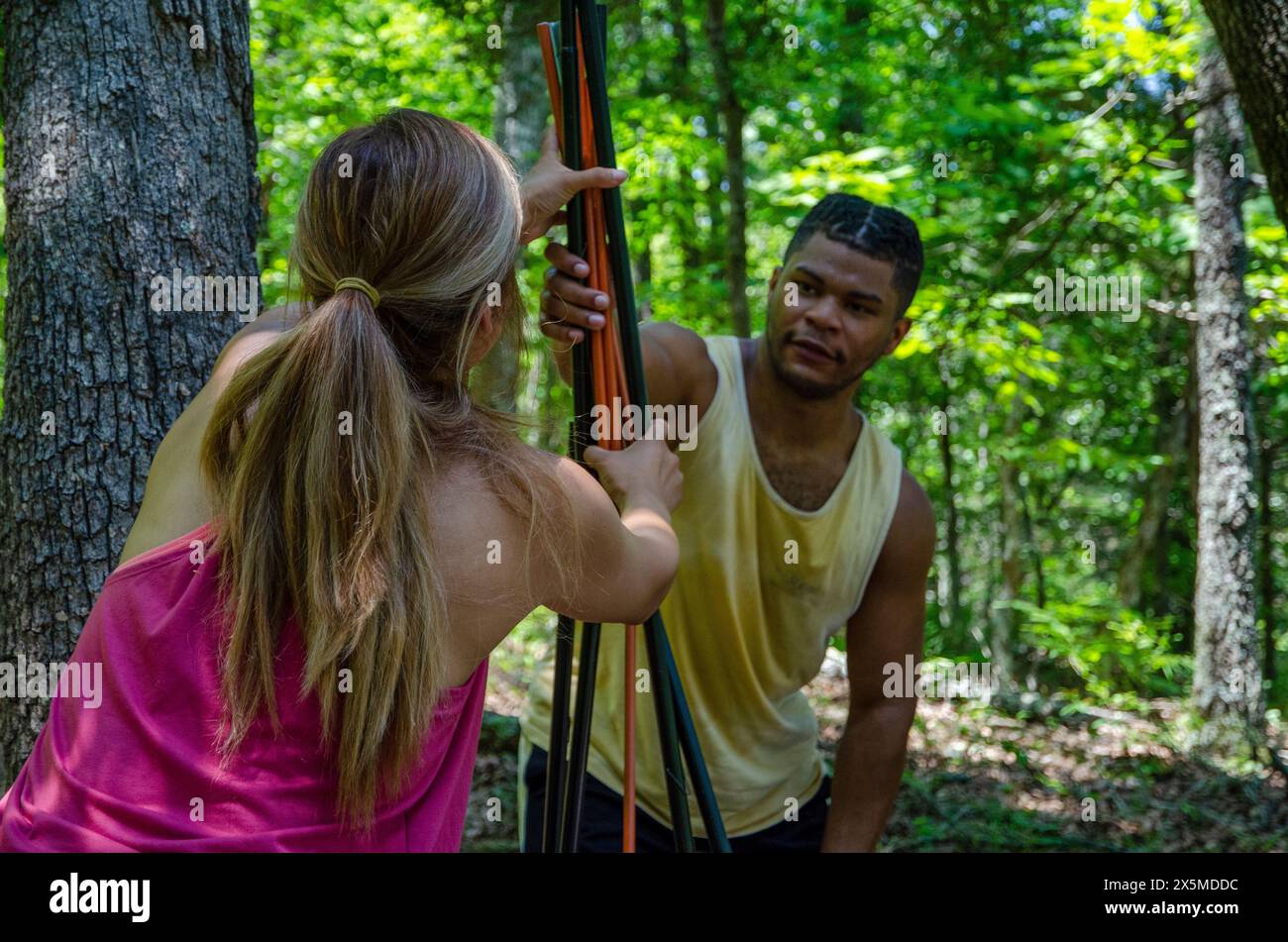 Les jeunes installent une tente dans la forêt Banque D'Images