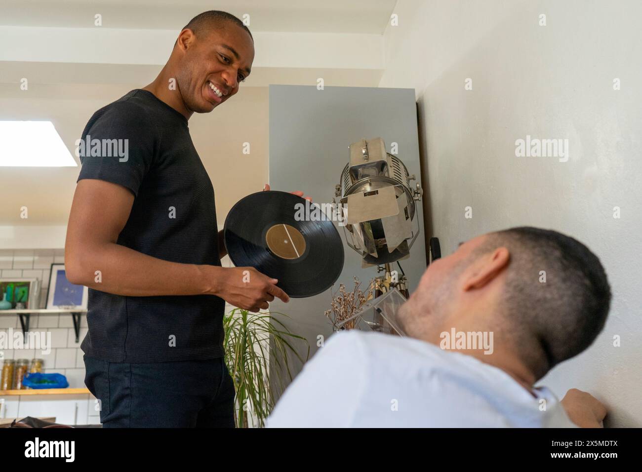 Royaume-Uni, Londres, couple gay souriant choisissant des disques vinyles dans le salon Banque D'Images