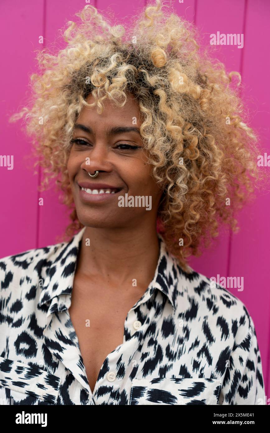 Femme souriante avec des cheveux bouclés Banque D'Images