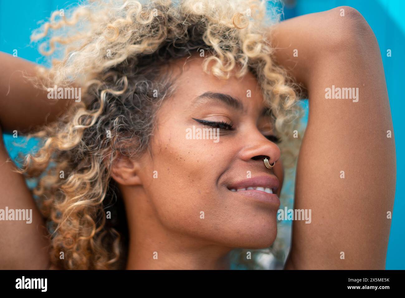 Gros plan d'une femme souriante avec des cheveux bouclés Banque D'Images