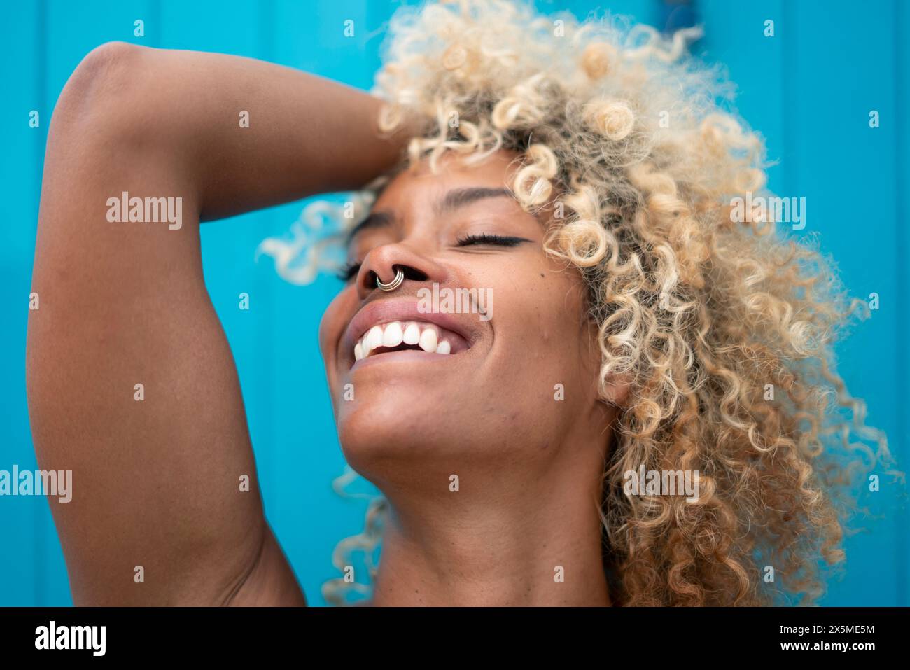 Gros plan d'une femme souriante avec des cheveux bouclés Banque D'Images