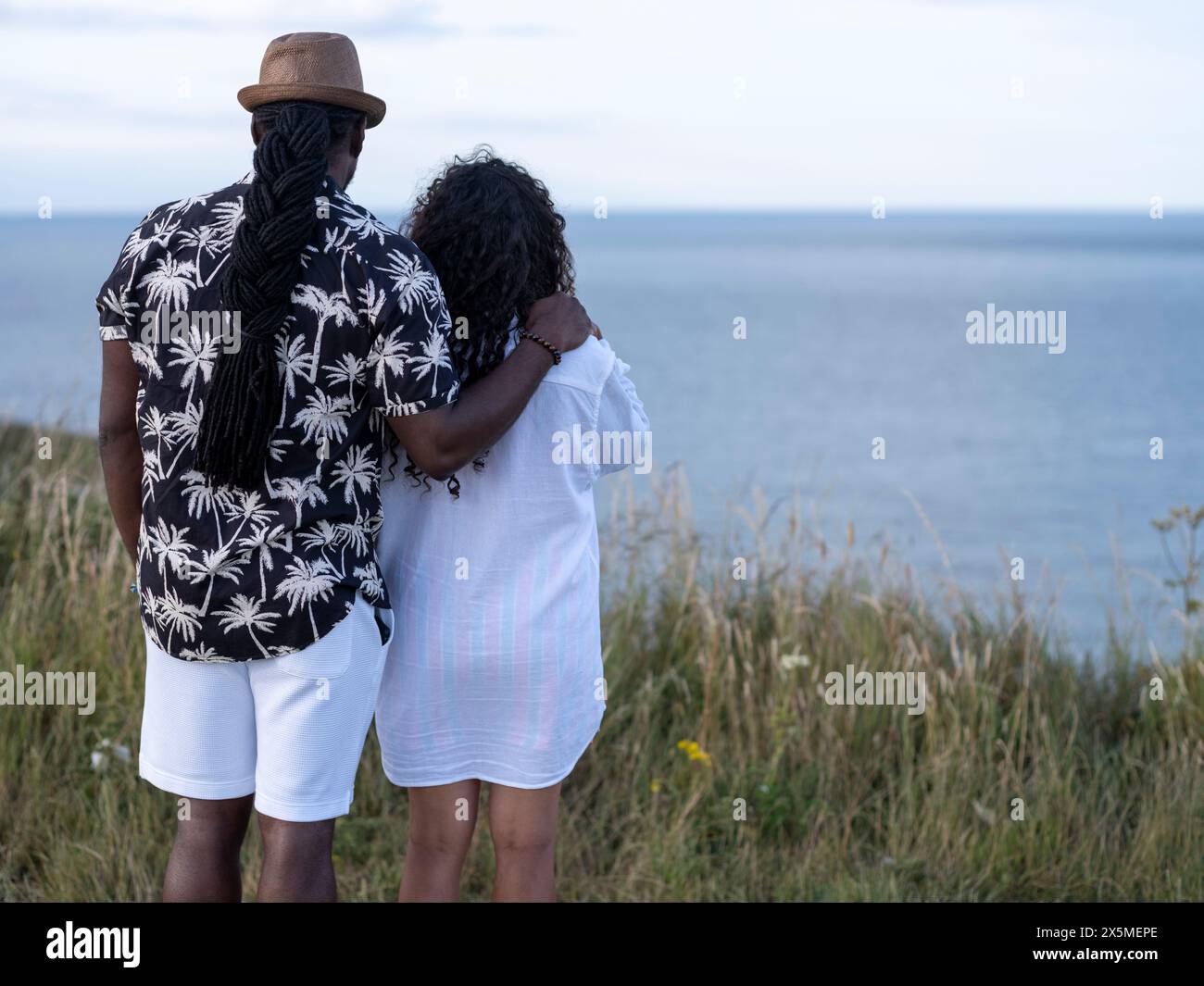 Couple regardant la mer depuis la falaise Banque D'Images