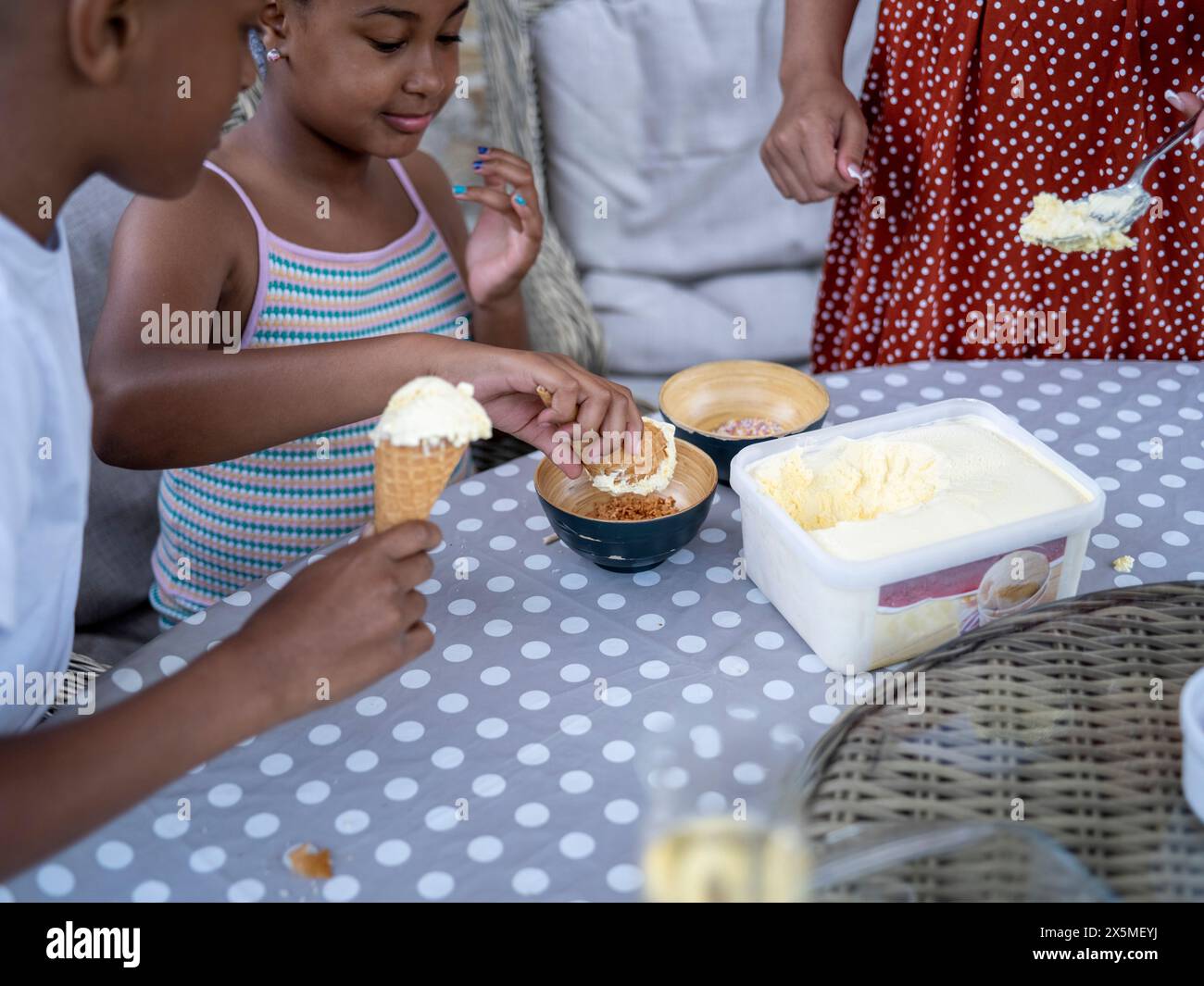 Mère et enfants fabriquant de la crème glacée (8-9, 10-11) Banque D'Images