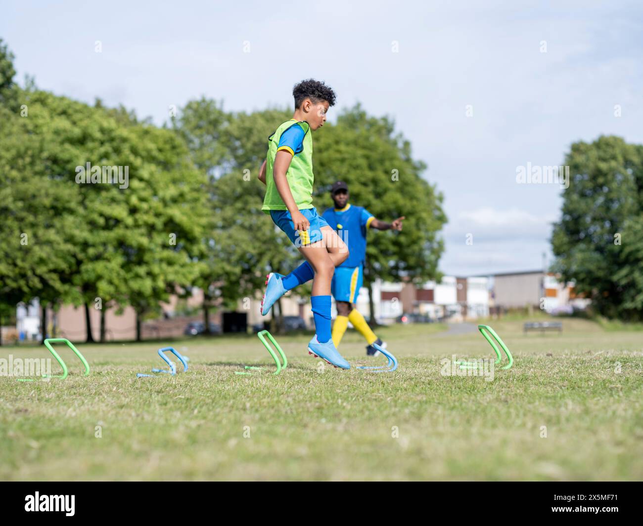 Enfants (8-9) vêtus d'uniformes pratiquant sur un terrain de soccer Banque D'Images