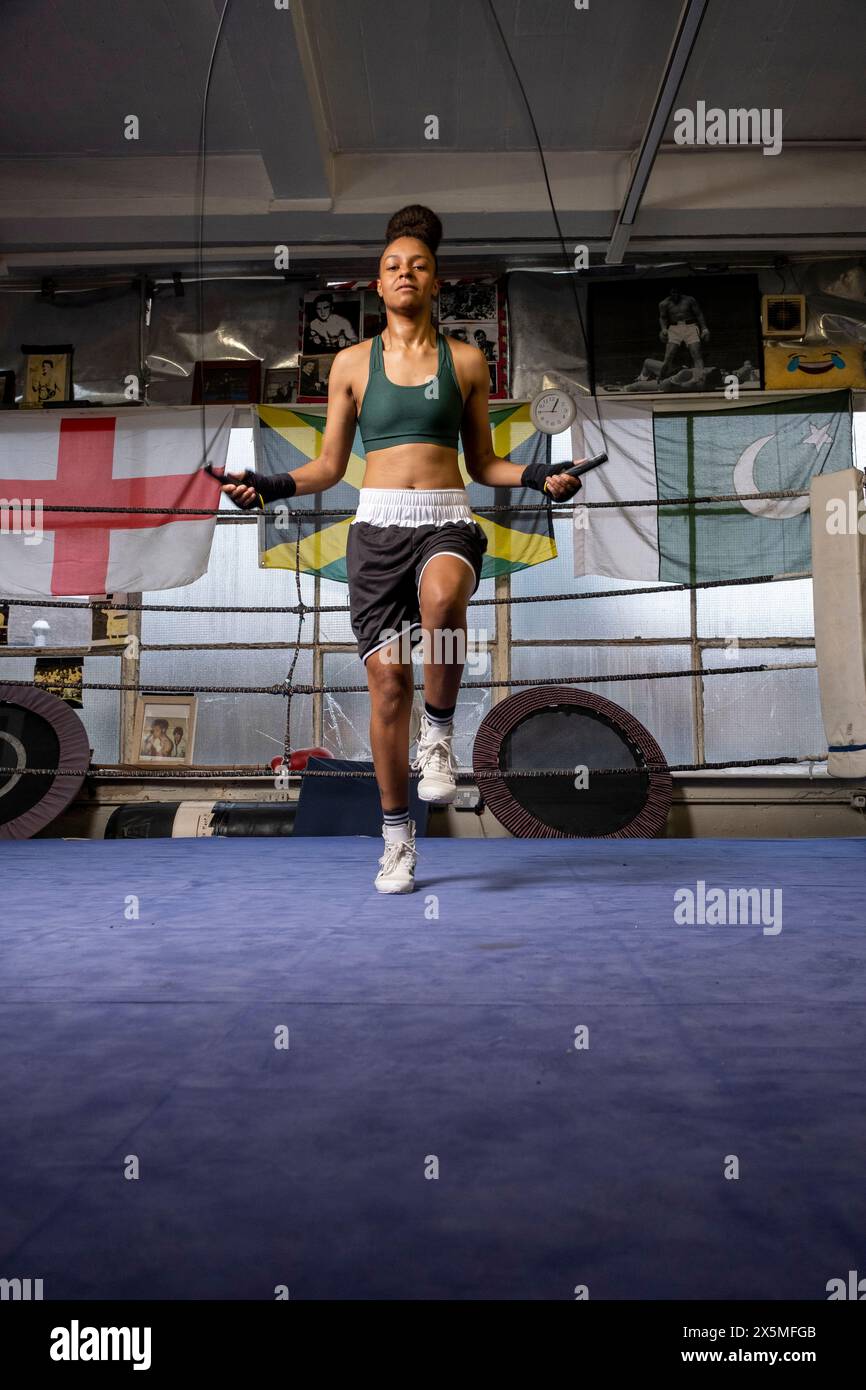 Jeune femme exerçant dans le ring de boxe Banque D'Images