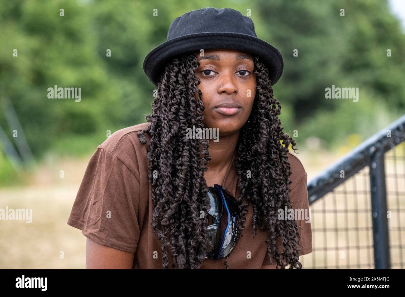 Portrait d'une femme aux longs cheveux bouclés portant un chapeau noir Banque D'Images