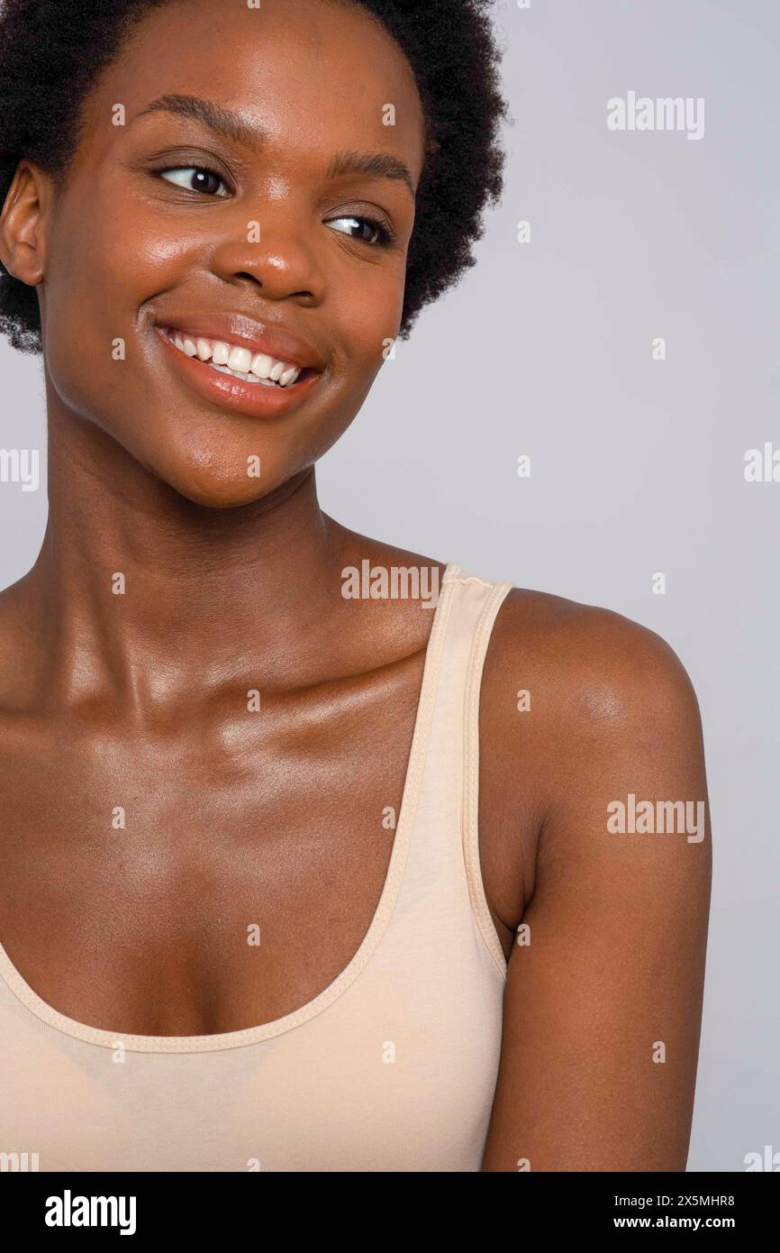 Portrait de studio de femme souriante dans le débardeur de couleur crème Banque D'Images