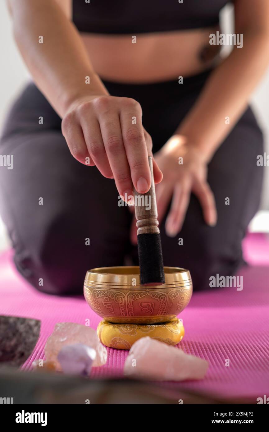 Gros plan de femme avec bol chantant dans le studio de yoga Banque D'Images