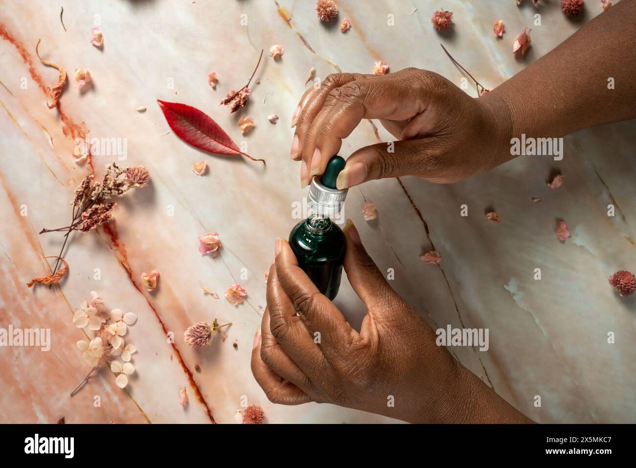 Femme tenant une bouteille en verre avec de l'huile essentielle Banque D'Images