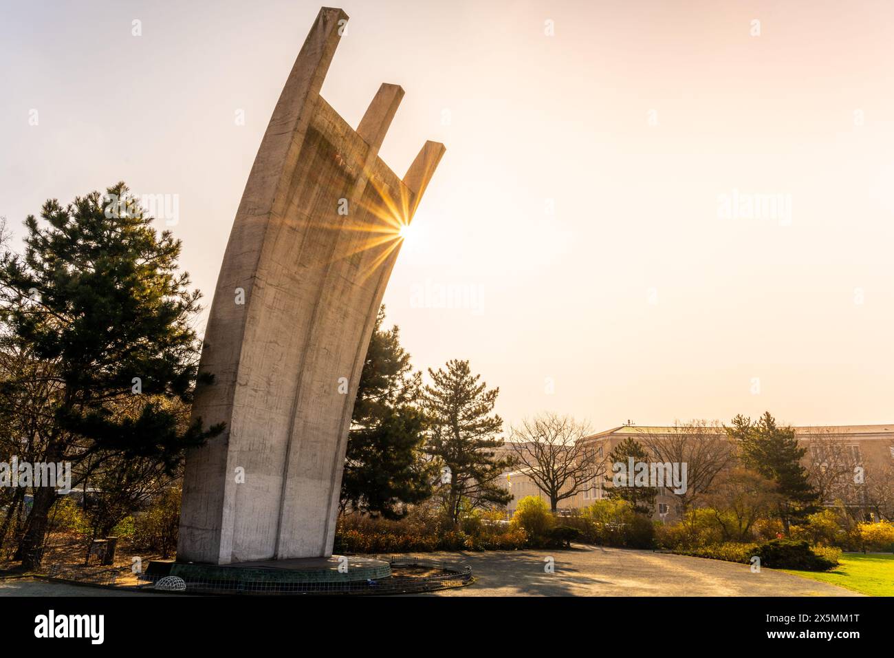 Le Berlin Airlift Memorial baignait dans la lueur chaude d'un lever de soleil, avec le terminal de l'aéroport Tempelhof en arrière-plan. Banque D'Images