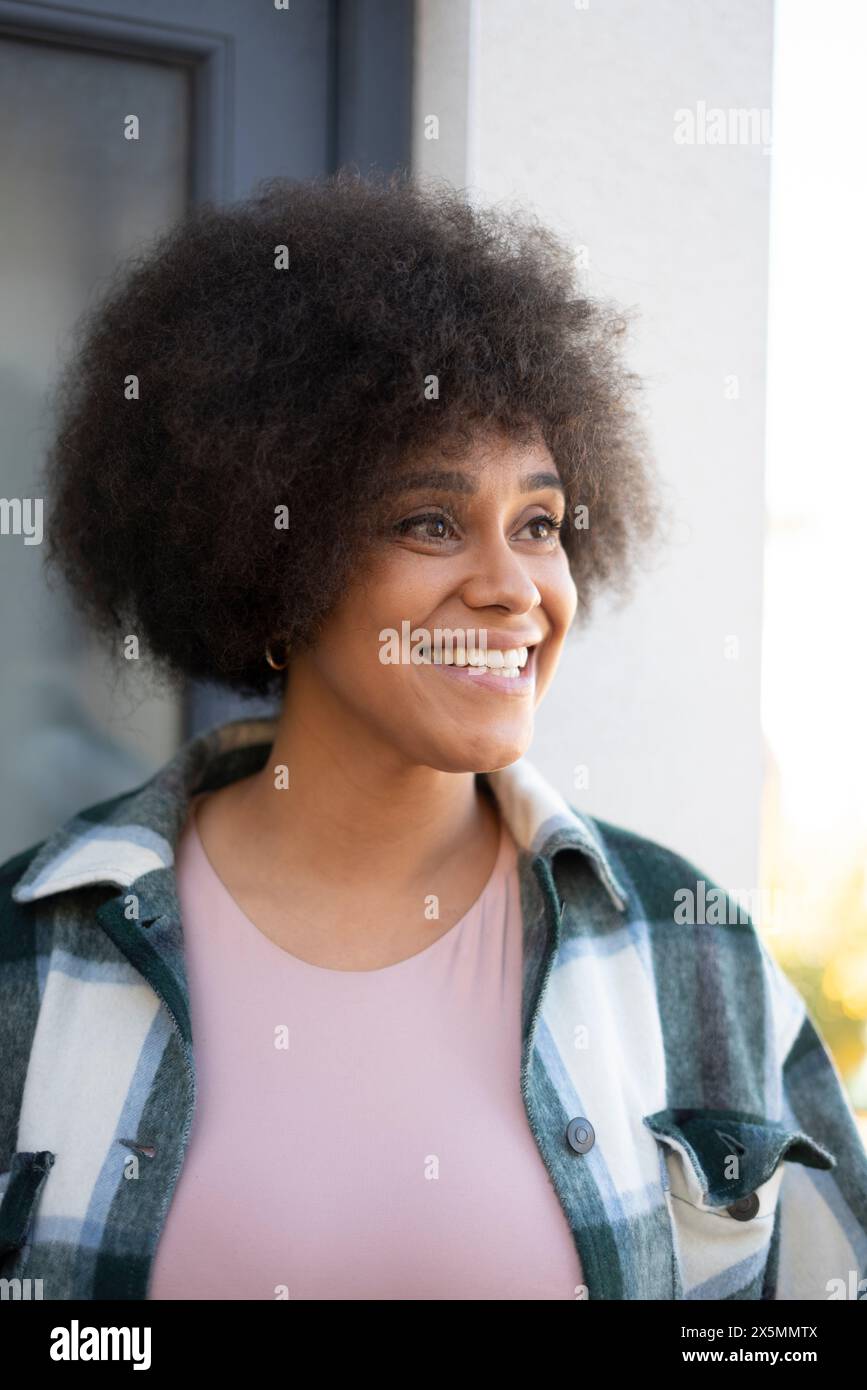 Femme souriante avec des cheveux bouclés Banque D'Images