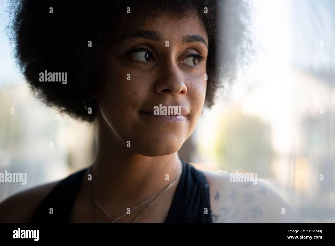 Femme souriante avec des cheveux bouclés Banque D'Images