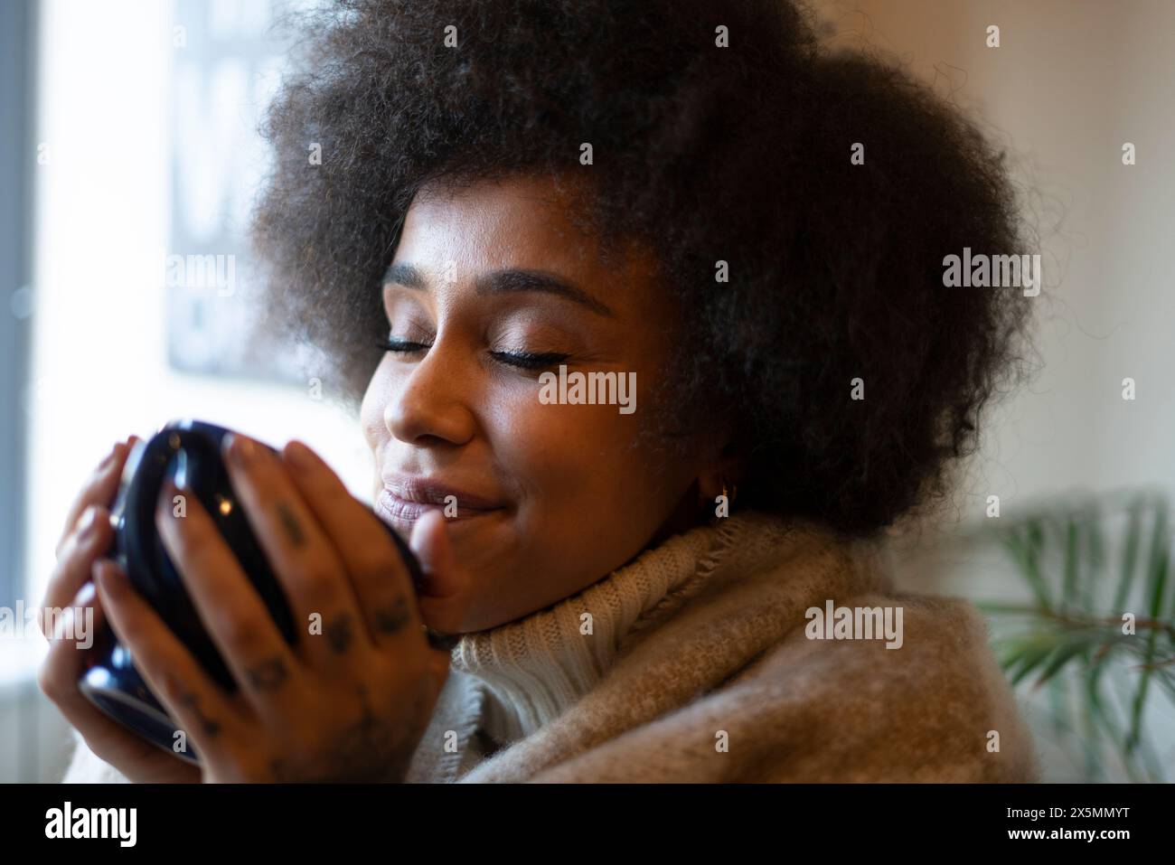 Femme buvant du mug à la maison Banque D'Images