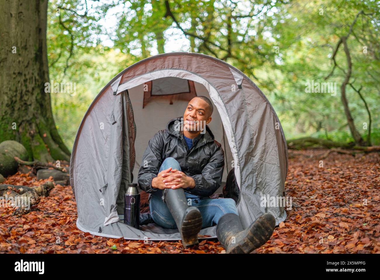 Homme campant dans la forêt à l'automne Banque D'Images