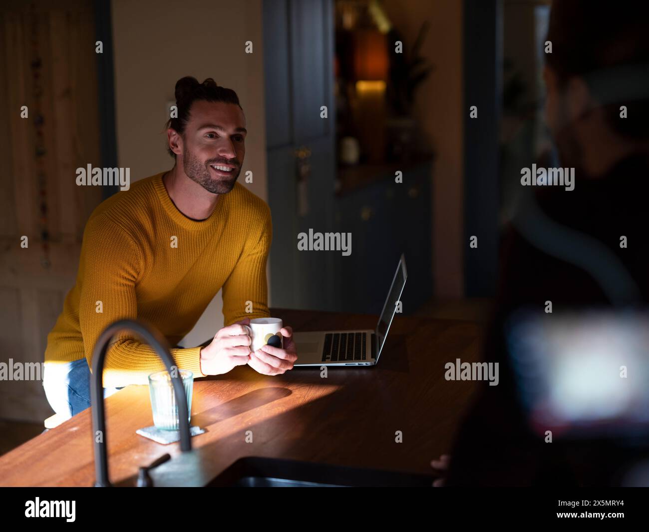 Couple gay parlant à Kitchen Island Banque D'Images