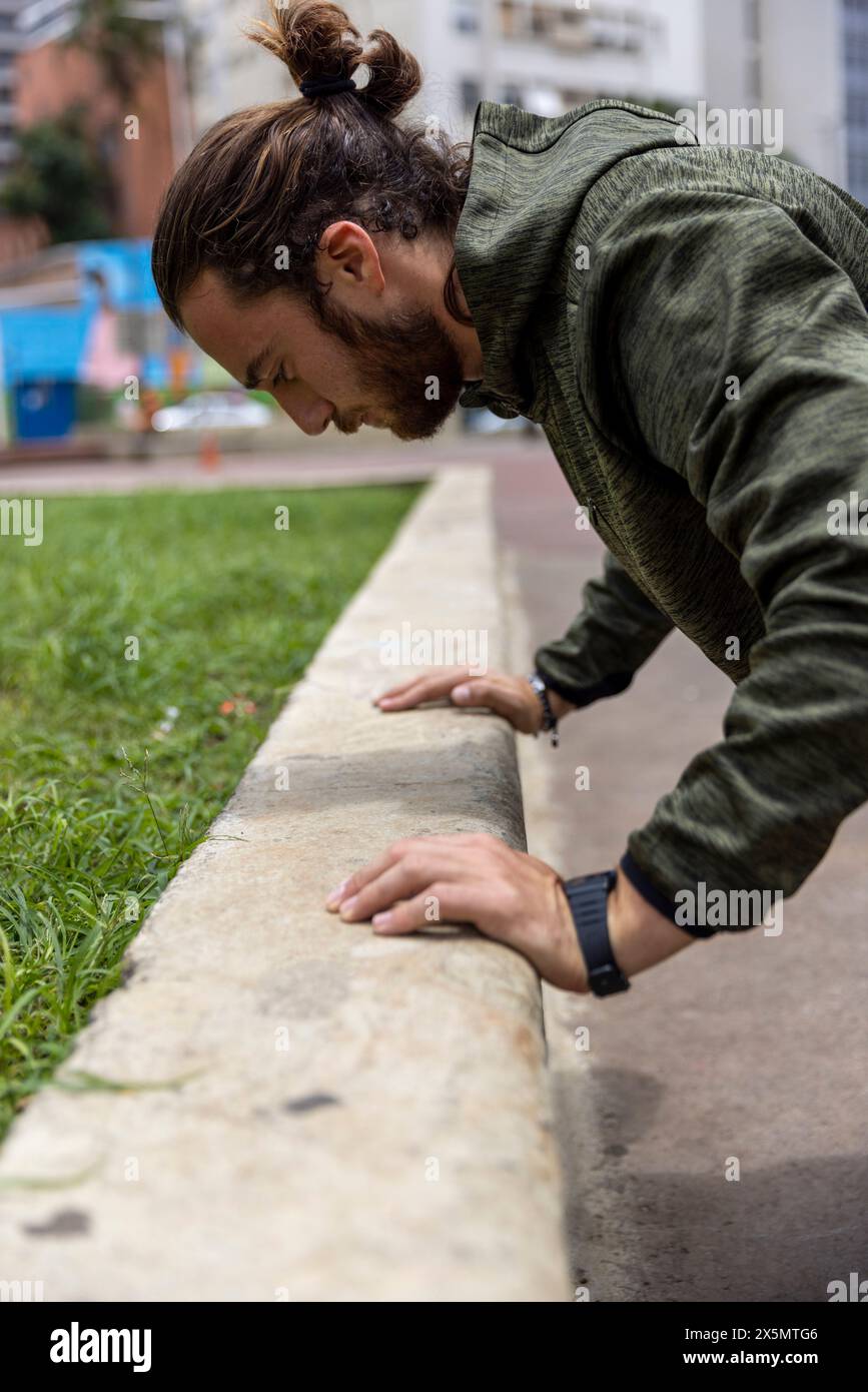 Brésil, Sao Paulo, homme en vêtements de sport faisant des pompes en ville Banque D'Images