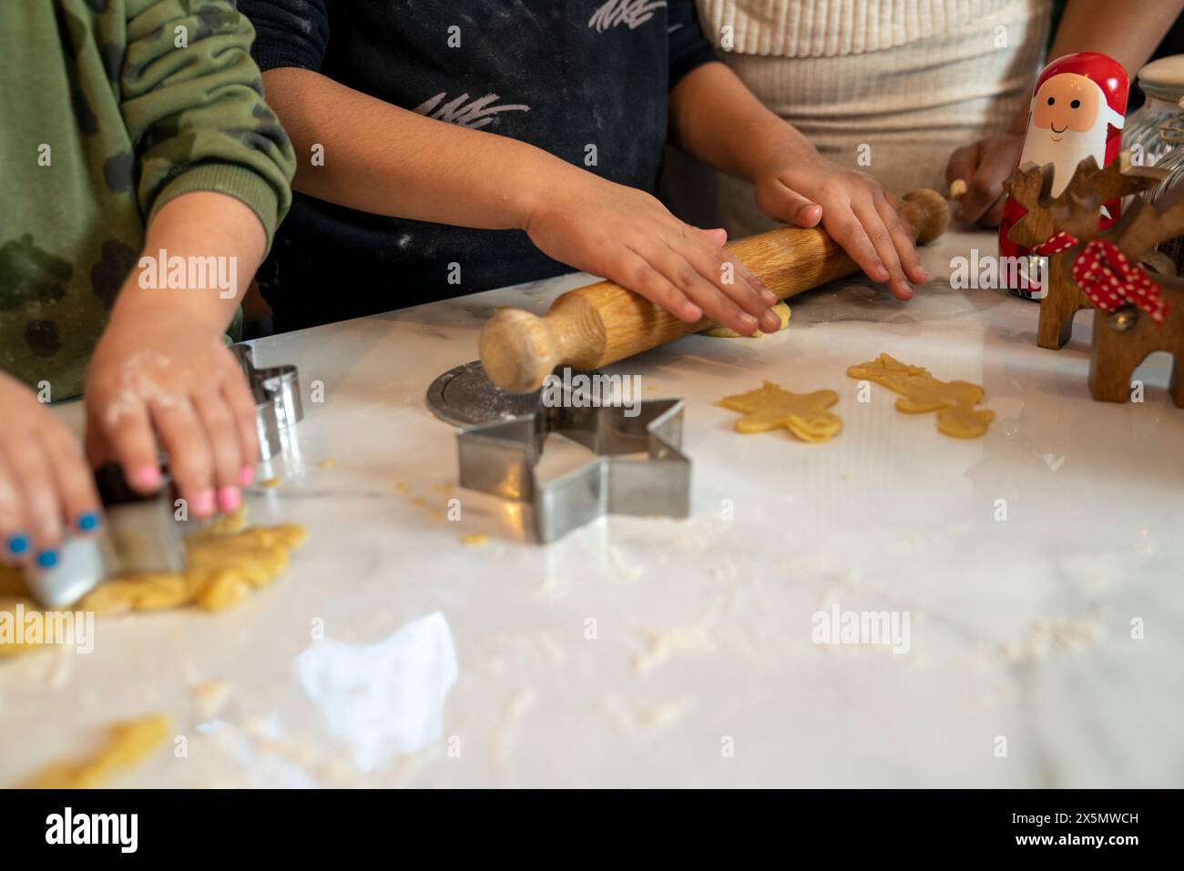 Maman avec des enfants préparant des biscuits de Noël dans la cuisine Banque D'Images