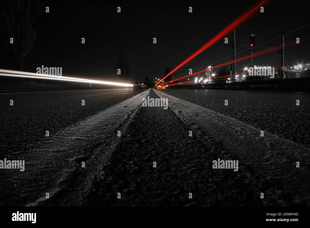 Photographie de nuit longue exposition avec feux de circulation sur l'autoroute, éclairant les pistes de vitesse et de lumière sur Dark Street au crépuscule, zone industrielle Banque D'Images