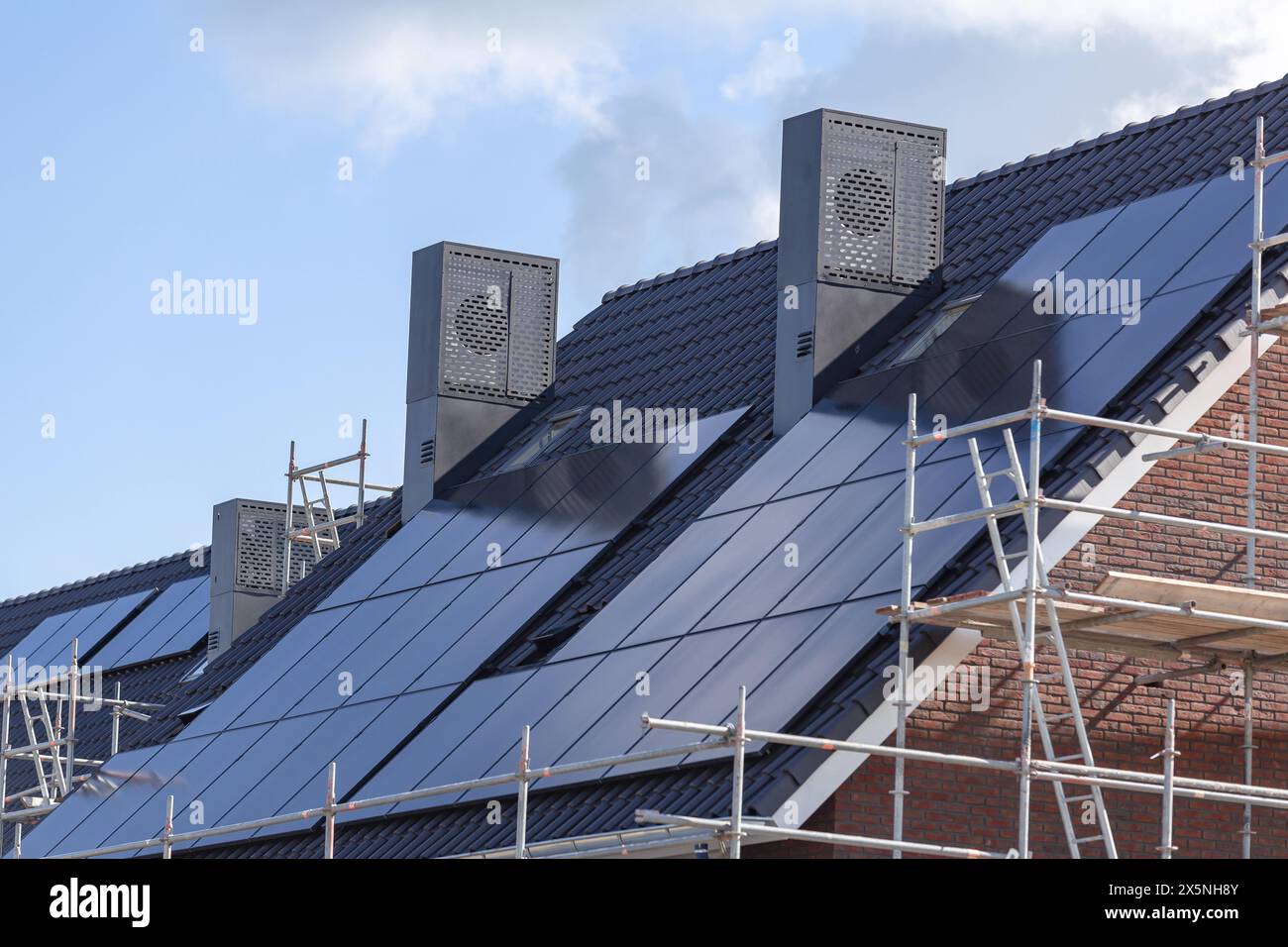 Panneaux solaires sur les toits en tuiles des nouveaux bâtiments. Banque D'Images