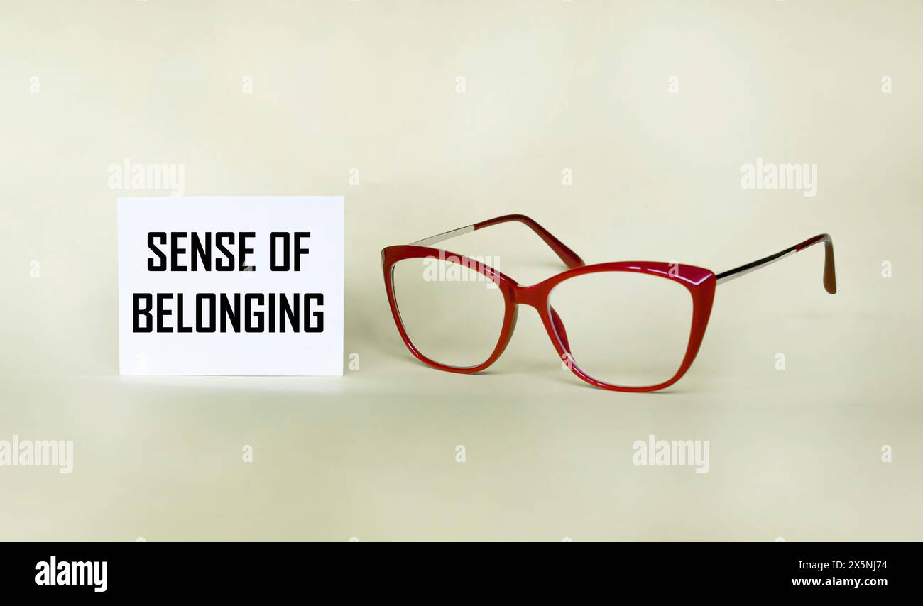 Sentiment d'appartenance signe sur un bloc-notes sur un fond clair avec des lunettes. Banque D'Images