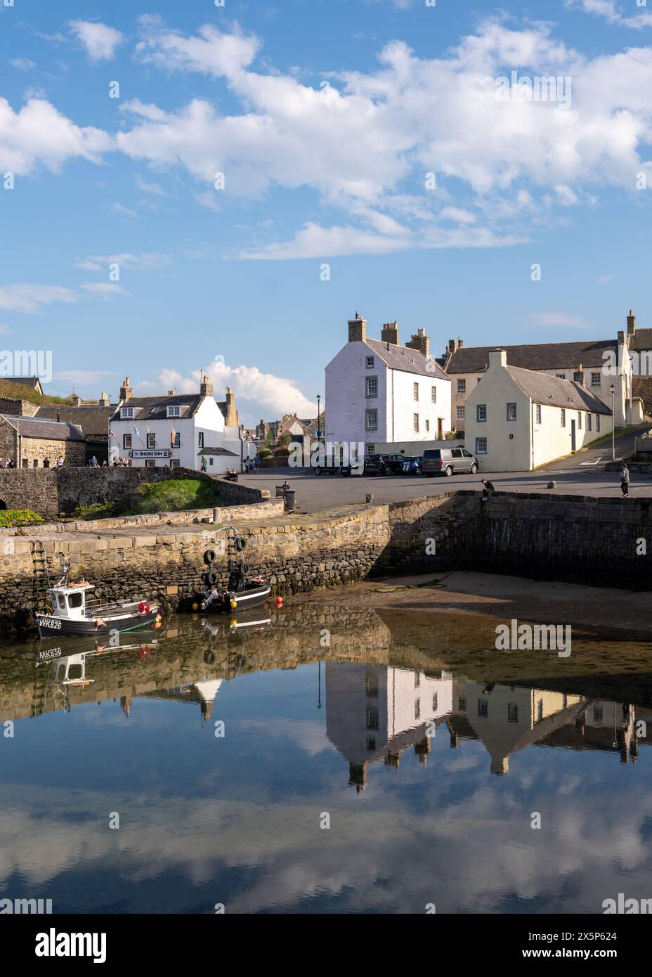 Portsoy, Aberdeenshire, Royaume-Uni. 10 mai 2024. C'est la zone portuaire de la ville de pêcheurs de Portsoy où le tournage de la dernière série de Peaky Blinders a été réalisé. La région se reflète sur l'eau calme du port et le Shore Inn est occupé avec des clients en plein air. Crédit : JASPERIMAGE/Alamy Live News Banque D'Images