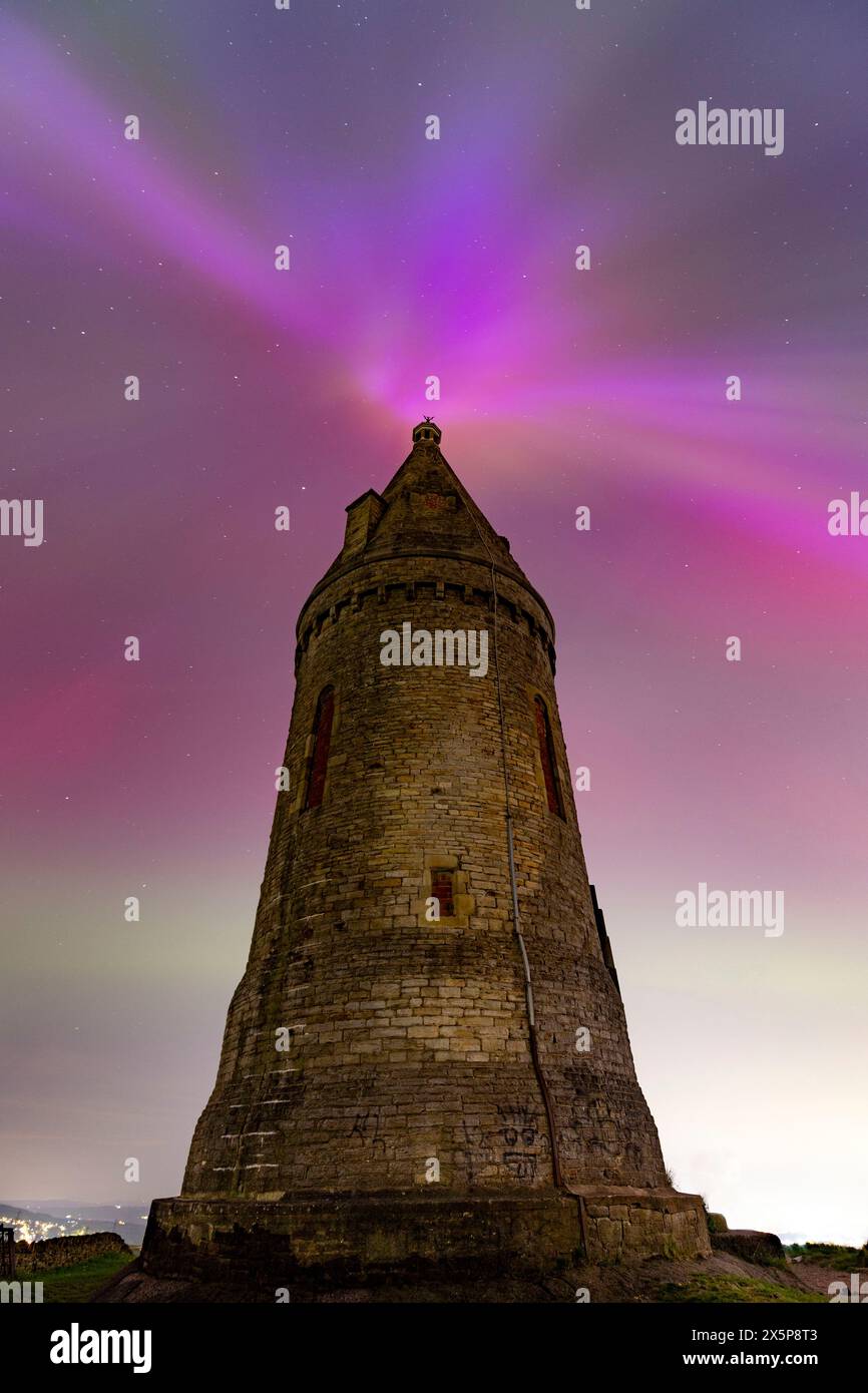Les aurores boréales (ou aurores boréales) brillent derrière Hartshead Pike à Tameside, dans le Grand Manchester, en Angleterre, alors que l'une des tempêtes géomagnétiques les plus fortes depuis des années frappe la terre. Photo : Daniel Chesterton/phcimages.com crédit : PHC images LTD/Alamy Live News Banque D'Images