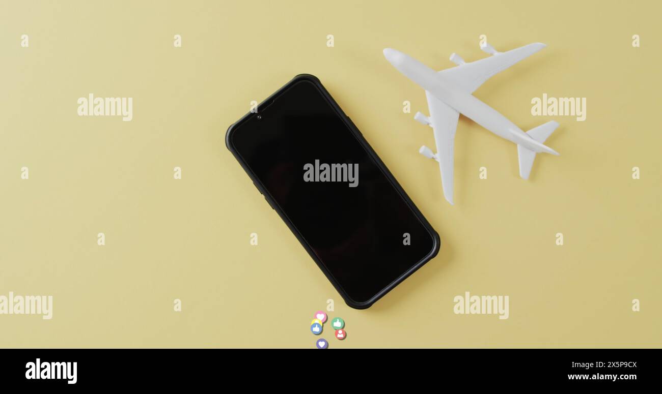 Smartphone près du modèle d'avion blanc avec des pilules colorées sur fond jaune Banque D'Images